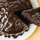 Chocolate cake on white plate with slice being removed